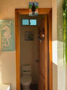 a bathroom with a toilet and a sign on the wall at Cerro Beach in Sinchal