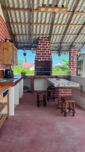 una cocina al aire libre con mesas y un horno de ladrillo en Cerro Beach, en Sinchal