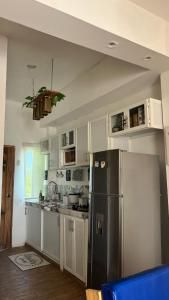 a kitchen with a stainless steel refrigerator and white cabinets at Cerro Beach in Sinchal