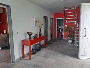 a living room with a red table and a staircase at Vivenda Moura, Caloura in Caloura +36 photos