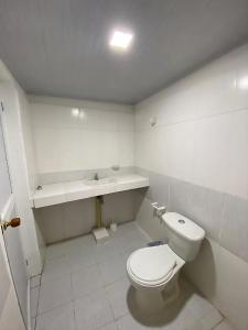 Un baño blanco con inodoro y lavabo. en Apartahotel Saroa, en Fonseca 19 fotos más