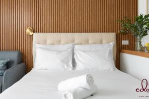 a bedroom with a bed with white sheets and pillows at Luxury living 100 meter from the beach - by Edom in Eilat