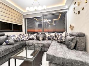 un soggiorno con divano e tavolo in vetro di Appartement VIP Panoramic Sea view et deluxe ad Al-Ḥoseyma