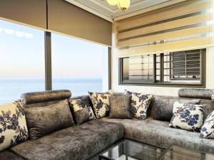 ein Wohnzimmer mit einem großen Sofa mit Kissen in der Unterkunft Appartement VIP Panoramic Sea view et deluxe in Al Hoceïma