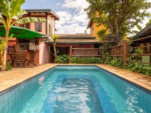 a swimming pool in front of a house at Pousada Atiaia in Ilhabela