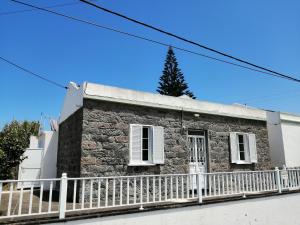 a stone house with a white fence at Casa Dos Mosteiros in Mosteiros