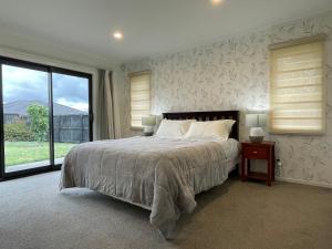 Ένα ή περισσότερα κρεβάτια σε δωμάτιο στο Modern，Spacious 5 bedroom house in north Hamilton