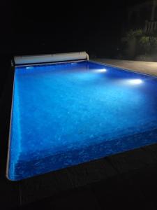 una piscina azul en una habitación oscura en Caufour, en Lédat