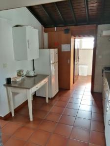 een keuken met een tafel en een koelkast bij Casa Dos Mosteiros in Mosteiros
