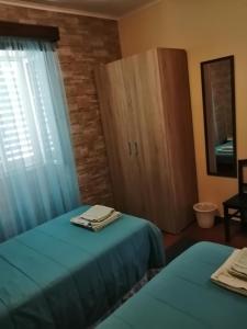 a room with two beds and a cabinet and a window at Casa Dos Mosteiros in Mosteiros