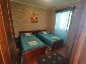 2 aparte bedden in een kamer met een raam bij Casa Dos Mosteiros in Mosteiros