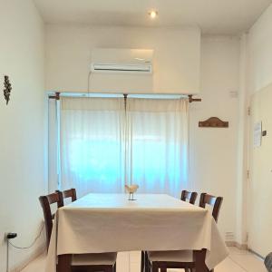 a dining room table with a white table cloth on it at BeelApt - Departamento elegante y seguro, con Cochera Exclusiva in La Plata