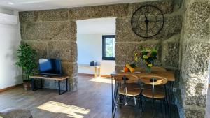 a dining room with a table and a clock on the wall at Casa do Geraço - Douro Guest House in Várzea do Douro