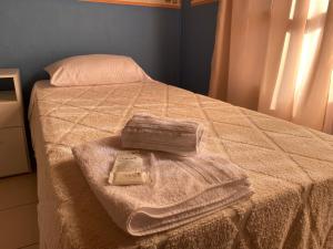Una cama con dos toallas encima. en Una casa amplia y centrica en Tunuyán