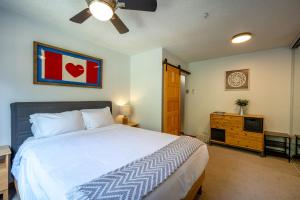 een slaapkamer met een groot bed en een televisie bij Cozy Creekside Two-Storey Condo in Whistler