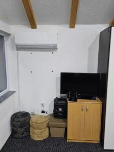 um quarto com uma televisão de ecrã plano e uma mesa em OAZA ZA DUŠU em Visoko