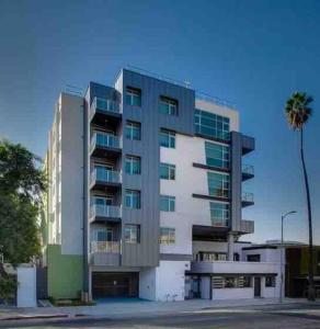 a tall building with a palm tree in front of it at New Designer Corner Penthouse 2 Bedroom w/ 3 Beds in Los Angeles