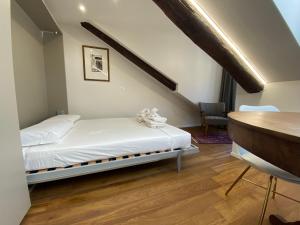 a small bedroom with a bed and a desk at Hostdomus - G10 Suite in Turin