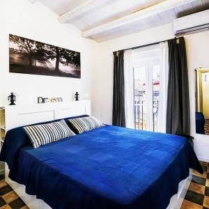 a bedroom with a blue bed and a window at CASAGIO' in Ragusa