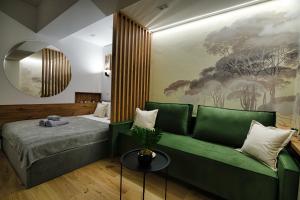- une chambre avec un canapé vert et un tableau mural dans l'établissement Good rest in 52, à Zator