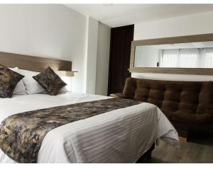 帕斯托hotel versalles的配有一张大床和一把椅子的酒店房间