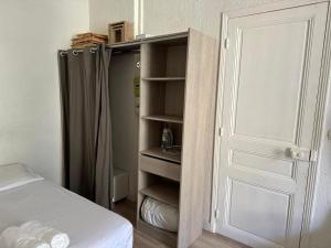 1 dormitorio con armario, cama y puerta en 600m port, tramway, clim, wifi, en Niza