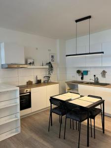 een keuken met een tafel en stoelen. bij Luxuriöses Apartment für 4 Personen, Neubau, Parkplatz free in Bochum