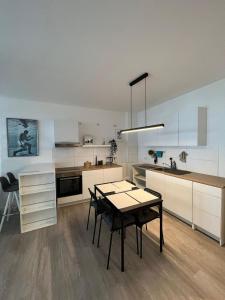 een keuken met een tafel en een eetkamer bij Luxuriöses Apartment für 4 Personen, Neubau, Parkplatz free in Bochum