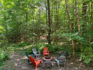 a group of chairs and a table in the woods at Lake Lauderdale Campground in Cambridge