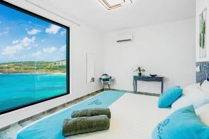 a room with a large screen tv and a large window at condostmaarten by the sea in Koolbaai