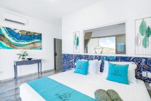 a bedroom with a bed with blue and white pillows at condostmaarten by the sea in Koolbaai