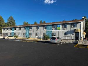 un gran edificio con coches estacionados en un estacionamiento en SureStay Hotel by Best Western Williams - Grand Canyon, en Williams