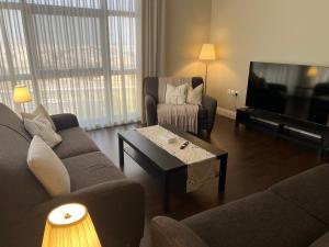 a living room with two couches and a television at Apartment Fourty One in Al Khobar