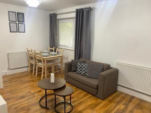 a living room with a couch and a table at T Lodge in Abbey Wood