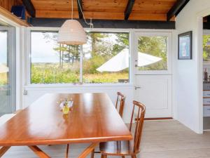 a dining room with a wooden table and a window at Holiday home Bindslev XXII in Bindslev