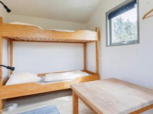 a bedroom with a bunk bed and a wooden table at Holiday home Bindslev XXII in Bindslev