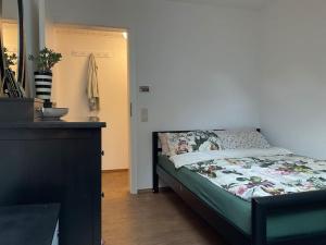 um pequeno quarto com uma cama e uma cómoda em Wohnung in idyllischem Örtchen em Meschede