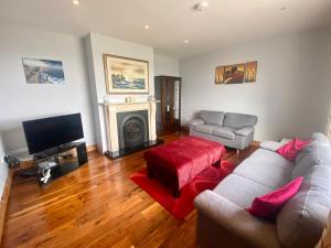 ein Wohnzimmer mit einem Sofa und einem Kamin in der Unterkunft Irish Isle Oasis: Spacious 5-Bedroom Retreat in Bungowla