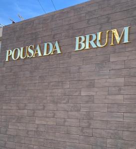 een bord aan de zijkant van een bakstenen gebouw bij Pousada Brum in Pelotas