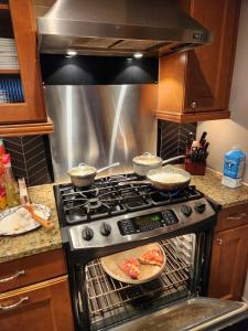 a kitchen with an oven with two slices of pizza at Wrigley 2 bedroom 2 bath with free parking & yard! in Chicago