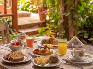 a table topped with plates of breakfast foods and drinks at Pousada Atiaia in Ilhabela