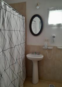 y baño con cortina de ducha y lavamanos. en La Candelaria - Casas de Campo - en Sierra de la Ventana