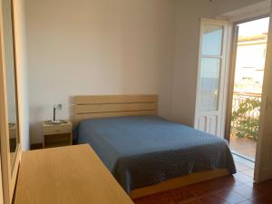 Schlafzimmer mit einem Bett, einem Tisch und einem Fenster in der Unterkunft Casa vacanze Marina di Camerota in Marina di Camerota