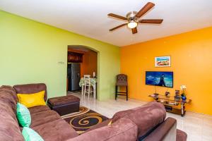 a living room with a couch and a ceiling fan at J&R Sunshine Retreat in Spanish Town