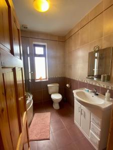 baño con lavabo y aseo y ventana en Irish Isle Oasis: Spacious 5-Bedroom Retreat en Bungowla