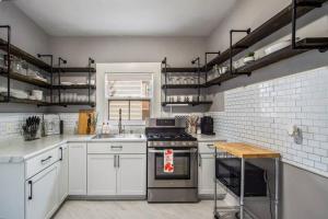 uma cozinha com armários brancos e um forno com placa de fogão em Entire 4 Bdrm Beautiful Home Next to WMU/K College em Kalamazoo