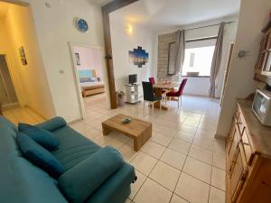a living room with a blue couch and a table at Appartamento Via Marinedda 9 Isola Rossa in Isola Rossa