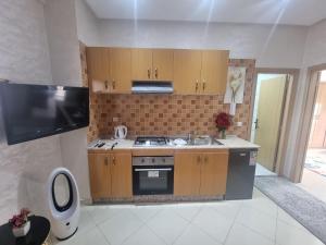 a kitchen with a stove and a sink and a tv at Best Appertement in haut founty in Agadir