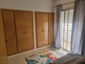 a bedroom with wooden cabinets and a bed next to a window at Best Appertement in haut founty in Agadir