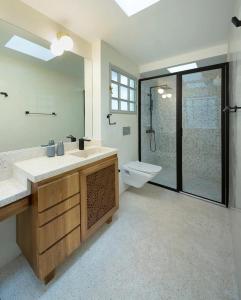 y baño con lavabo, ducha y aseo. en AmazINN Places Casa Bandera III, en Panamá